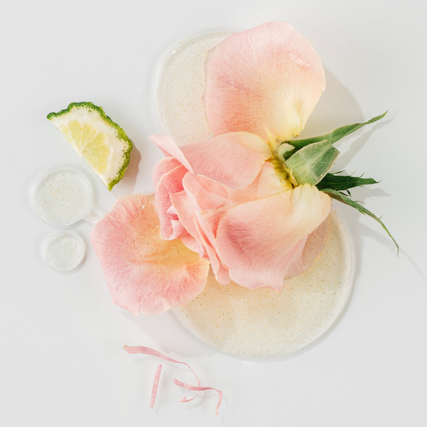 Decorative plate with pink flowers and a lime wedge on a white background