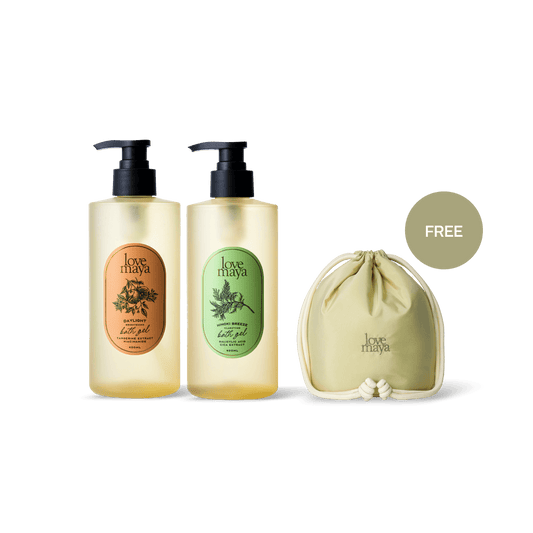 Two Love Maya bath gel bottles with pump dispensers and a matching drawstring pouch, shown on a clean white background with a green 'FREE' badge.